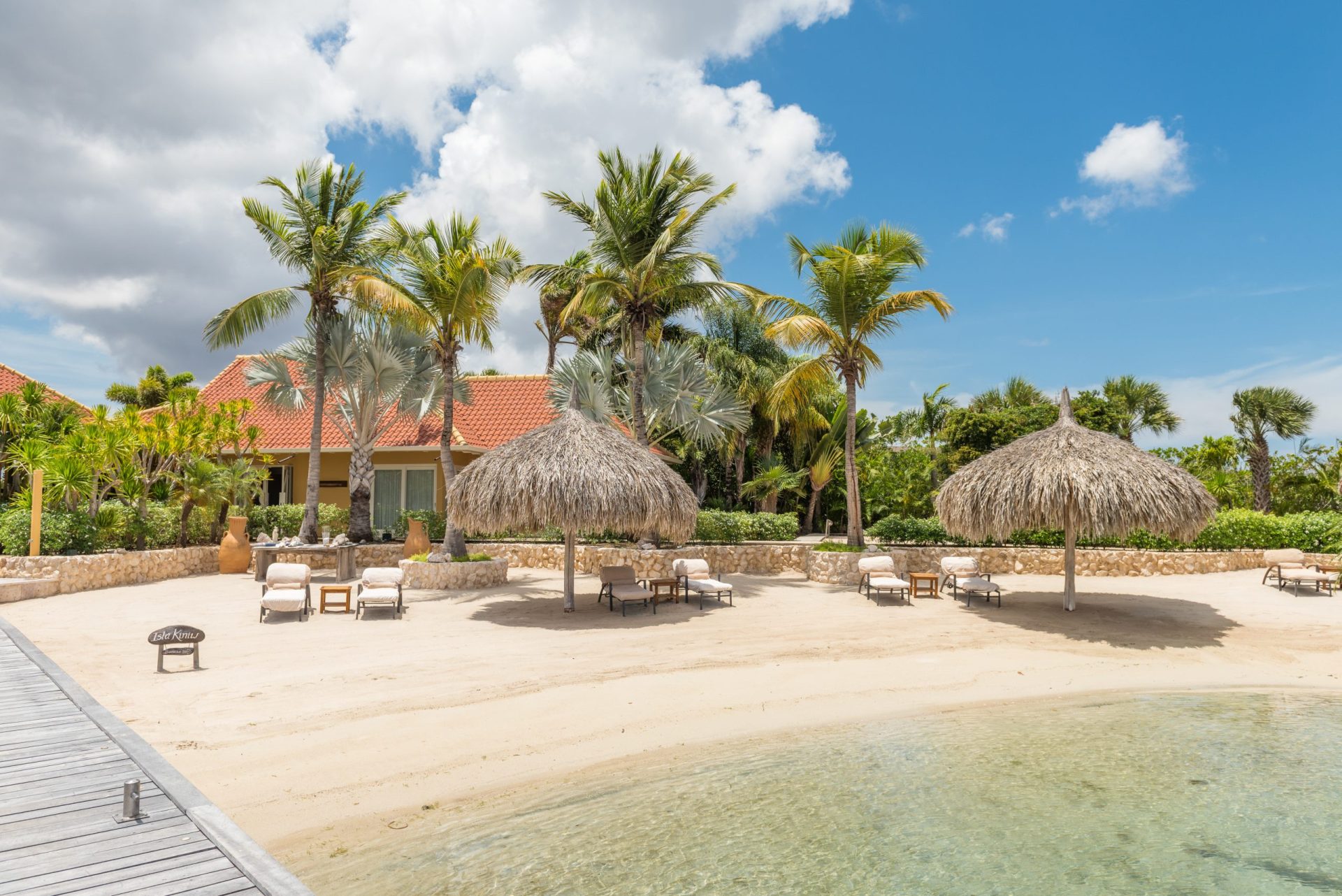 The beach at Isla Kiniw with a villa behind the beach
