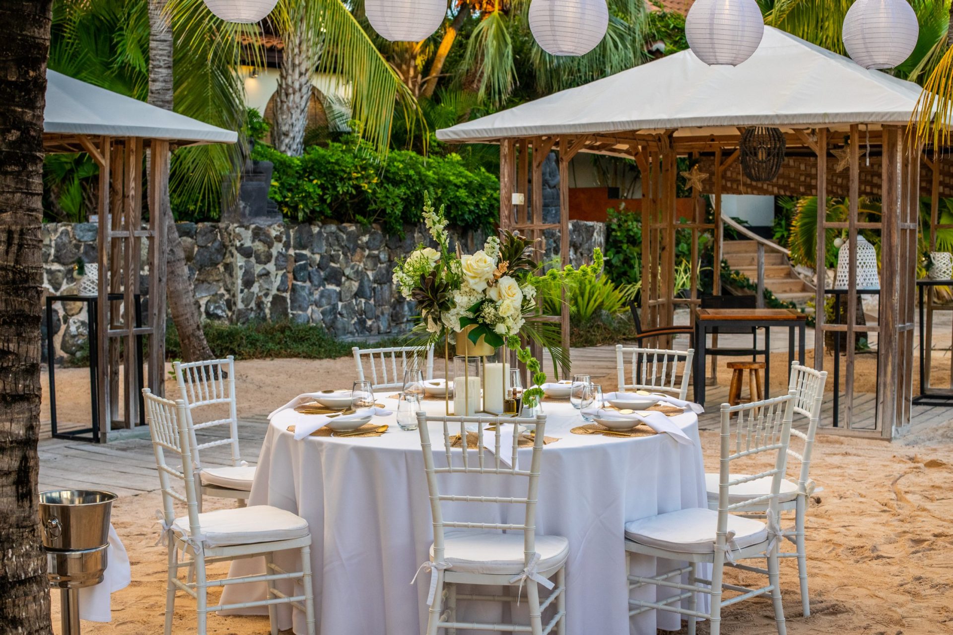 A table at Baoase set-up for dining on the beach with new years lanterns hanging above the table
