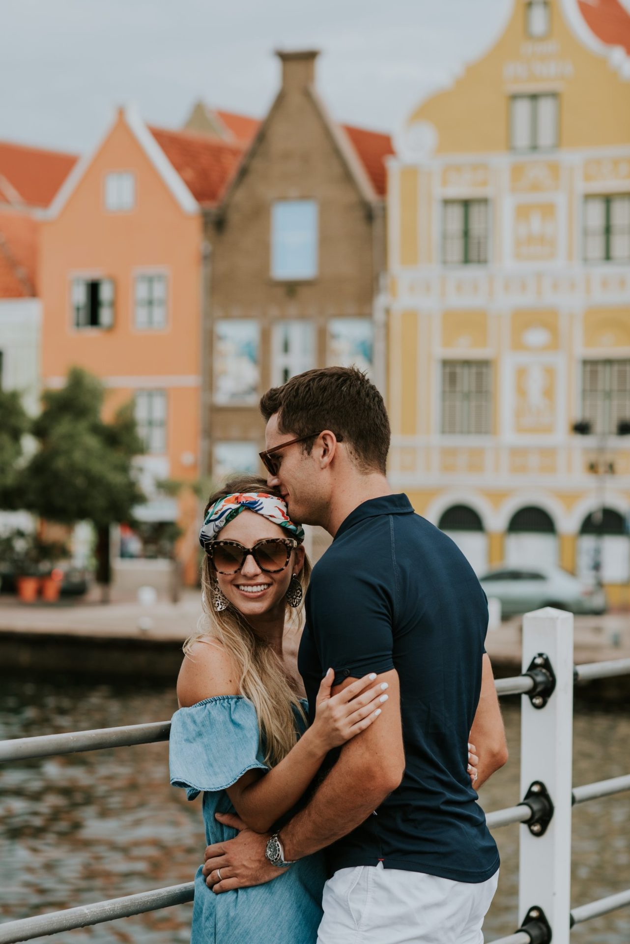 Man and woman hugging on the Pontjesbrug in Punda. The man kisses the forehead of the woman.